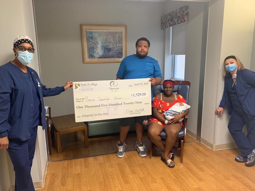 The Vintson family receives a contribution for their new son's Path2College 529 Plan due to the fact that he was the first "Tax Day Baby" at The Medical Center, Navicent Health.